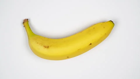 Top View Single Fresh Yellow Banana Rotating On White Background 4K Stock Footage 322143879