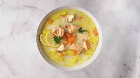 Top view of single plate with delicious salmon cream soup on white background Stock Footage 138377165