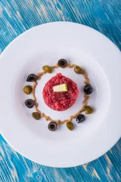 Top view on single portion of beef tartar steak on white plate Stock Photos