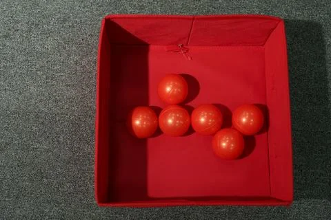 Top view of six red plastic balls inside a red storage box Stock Photos
