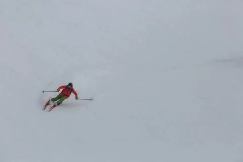 Top view of a skier going down a steep frozen slope in the mountains Foto stock