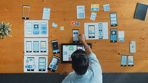 Top view of skilled developer walking and placing Ux Ui software. Convocation. Stock Photos