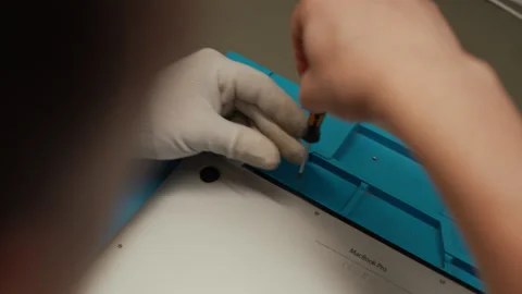 Top view of skilled technician performing laptop repair, disassembling Stock Footage 308160784