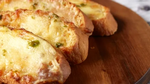 Top view of slice of garlic bread on black background 스톡 동영상 203222545