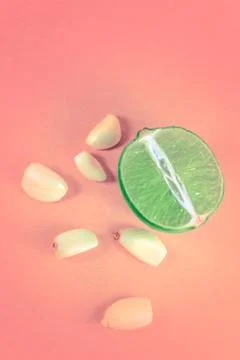 Top view of a slice of lemon surrounded by garlic cloves over a background of Stock Photos