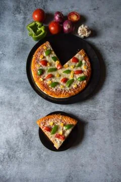 Top view of a slice of pizza served from a whole pizza Stock Photos