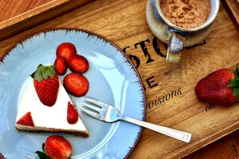 Top view of a slice of raw white strawberry cake on a blue plate. Photos