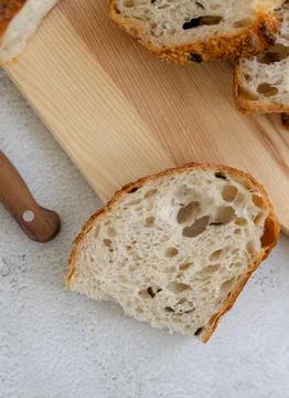 Top view of slice of sourdough bread with black olives on wooden table desk.. Stock Photos