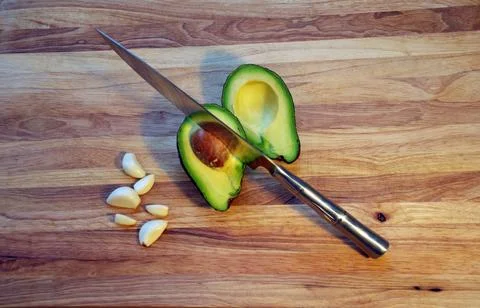 Top View of Sliced Avocado with Sharp Chef Knife on Wooden Cutting Board Stock Photos