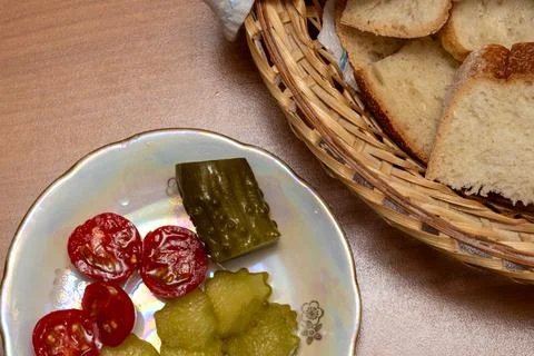 Top view of sliced bread in a basket and pickled vegetables on a plate. 写真素材