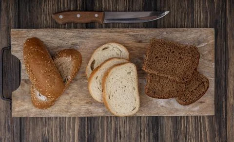Top view of sliced breads as seeded brown cob white and rye ones on cutting.. Stock Photos