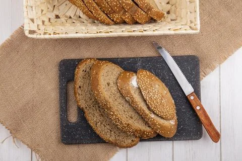Top view of sliced brown seeded cobs in basket and on cutting board with kn.. Stock Photos