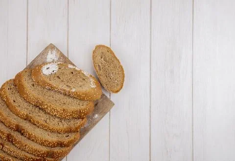 Top view of sliced brown seeded cob on cutting board and on wooden backgrou.. Stock Photos