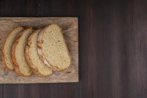 Top view of sliced crusty bread on cutting board on wooden background with .. Stock Photos