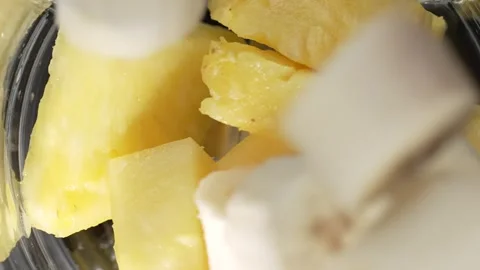 Top view of sliced pineapple and banana falling into blender jar in slow mo.. Stock Footage 315068150