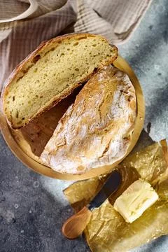 Top view of sliced rustic bread on wooden cutting board with butter Stock Photos