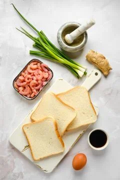 Top view of slices of bread on cutting board and ingredients for toasts Foto stock