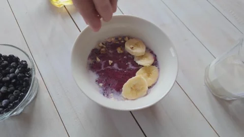 Top view slow motion adding chopped walnuts into oatmeal bowl, wholesome he.. Stock Footage 329843197