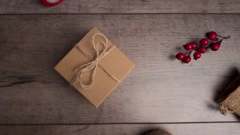 Top view slow motion clip sliding left over gift box and berries on rustic .. Stock Footage 321545441
