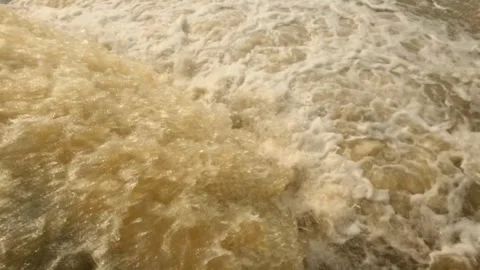 Top view slow motion of a rushing, murky brown waterfall Stock Footage 323042321