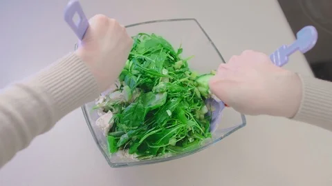 Top view, slow motion, a salad in a glass salad bowl made from chicken and green Stock Footage 101098824