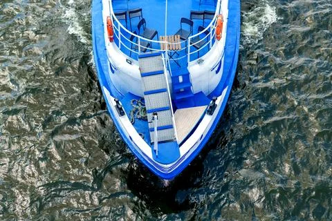 Top view: a small blue ship floating on the river Stock-Fotos