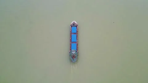 A top view of a small cargo ship slowly moving forward through calm waters. The  Stock Footage 287771342