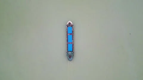 A top view of a small cargo ship slowly moving forward through calm waters. The  Stock Footage 287772628