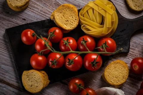 Top view on small cherry tomatoes on vintage worn chopping board Stock Photos