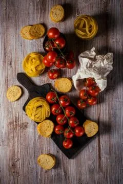 Top view on small cherry tomatoes on several twigs with tagliatelle Stock Photos