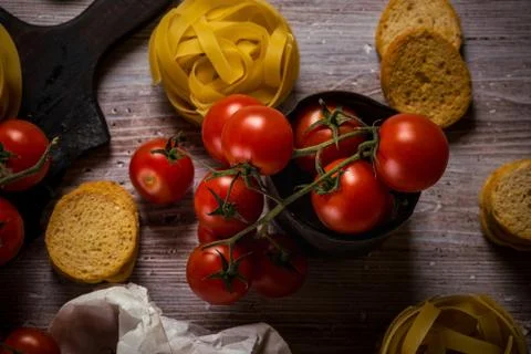 Top view on small cherry tomatoes in vintage worn can and pasta around Stock Photos