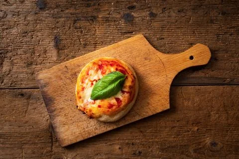Top view small pizza with basil leaf on cutting board 写真素材