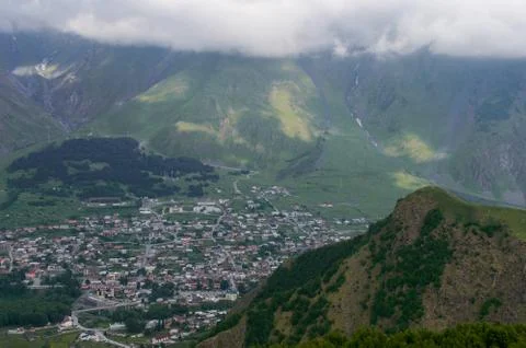 Top view of a small town spread out in a gorge among large evergreen mountain Stock Photos