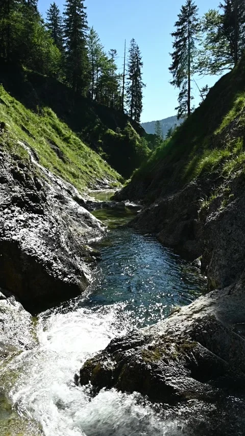 Top view of a small waterfall inside of a v-shaped valley, vertical, slow motion Stock-Footage 260880029