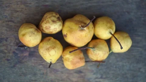 Top view of small yellow wild pears arranged on a rustic wooden table, slow moti Stock Footage 341888379
