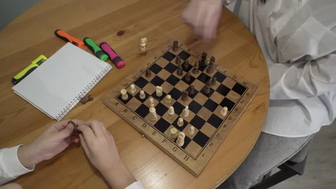 Top view a smart boy is playing chess with his mother in the kitchen Stock Footage 257588600