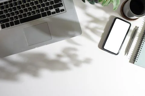 Top view of smart phone with empty screen, coffee cup, notepad and laptop o.. Stock Photos