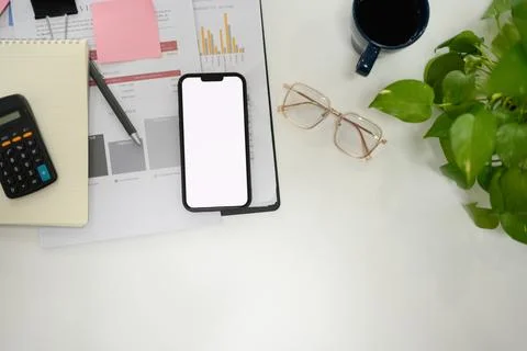 Top view smartphone with empty screen, glasses and business reports on white Stock Photos