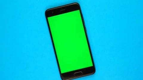 TOP VIEW: smartphone with green screen rotates on a blue background Vídeos de archivo 167238836