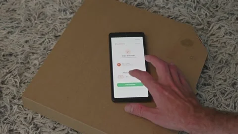 Top view of smartphone lying on cardboard pizza box with food delivery app Stock Footage 341569547