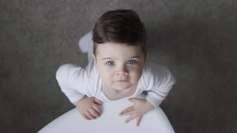 A top view of a smiling boy in white bodysuit. He is trying to get something Video stock 153888889