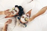 Top View Of Smiling Mother And Daughter Lying On Bed With Face Pack Stock Photos