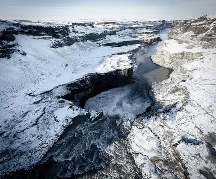 Top view of snow covered deep canyon and waterfall hole Stock Photos