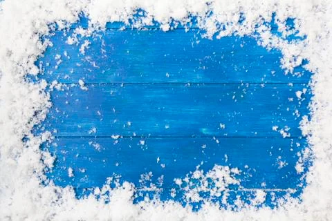 Top view of snow frame on blue wooden table with copy space. Winter or Christ Stock Photos