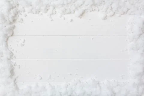 Top view of snow frame on white wooden background with copy space Stock Photos