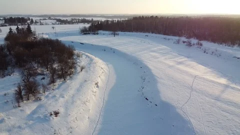 Top view of the snowy fields and forest. Quadrocopter shooting at sunset Stock-Footage 125317123
