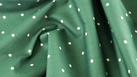 Top view of the soft folds of deep jungle green with white polka dots cotton  Stock Footage 293882872