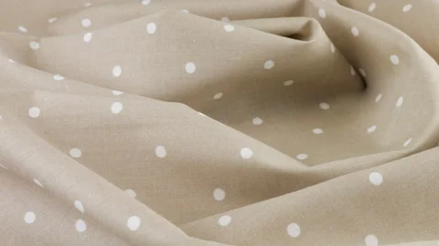Top view of the soft folds of light beige with white polka dots cotton fabric  Stock Footage 293884487
