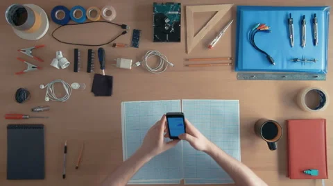 Top view software engineer is using cell phone smartphone on his desk full of 스톡 동영상 67365222