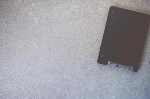 Top view of solid-state drive on a rough textured background with copy space Stock Photos